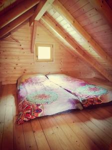 Cama en habitación de madera en un ático en Lesena hiška čebelnjak, en Loče pri Poljčanah