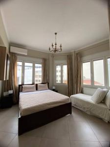 a bedroom with two beds and a chandelier and windows at Λabirinthia in Athens