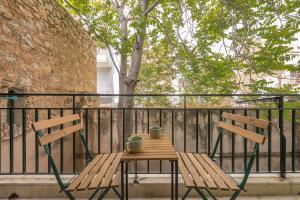 - deux chaises en bois et une table sur un balcon dans l'établissement Confy Living Apartment Metaxourghio Metro Station, à Athènes