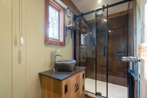 a bathroom with a sink and a shower at Bertha Shepherd's Hut in Lydney