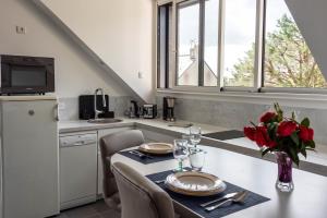 uma cozinha com uma mesa com um vaso de flores em L'Abri du Bon Vent em Cancale