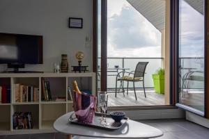L'Abri du Bon Vent في كانكال: غرفة معيشة مع طاولة وشرفة