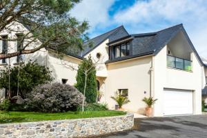 une maison blanche avec un toit noir et une allée. dans l'établissement L'Abri du Bon Vent, à Cancale