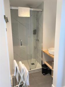 a bathroom with a shower with a glass door at Hôtel Le Goëlo - Port de Paimpol in Paimpol