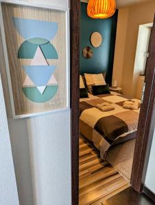 een slaapkamer met een bed en een spiegel bij L'Appar'T - Centre historique de Obernai in Obernai