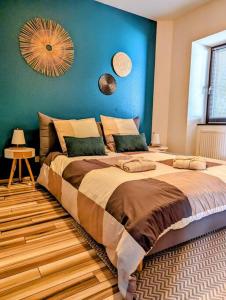 a bedroom with a large bed with a blue wall at L'Appar'T - Centre historique de Obernai in Obernai