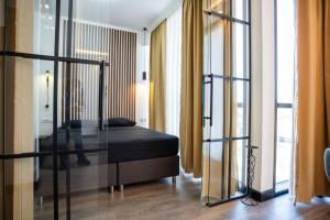 Schlafzimmer mit einem Bett mit Glastür in der Unterkunft Suite Music in Batajnica