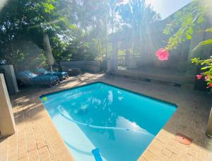 a swimming pool in a backyard with the sun shining at Pelican's Nest Holiday Home St Lucia in St Lucia