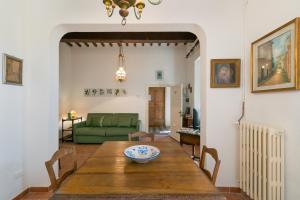 une salle à manger avec une table et un canapé vert dans l'établissement Nell'antica dimora, à Casciana Terme