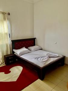 een bed in een kamer met een rode loper bij The Palace in Douala