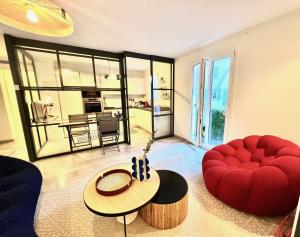 ein Wohnzimmer mit einem roten Stuhl und einem Tisch in der Unterkunft ApartHotel Riviera - BBB Vieille Ville - Splendide appartement de 3p AC avec Terrasse - LOFT PROVIDENCE in Nizza