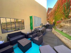 eine Terrasse mit Sofas, Tischen und einer Wand in der Unterkunft ApartHotel Riviera - BBB Vieille Ville - Splendide appartement de 3p AC avec Terrasse - LOFT PROVIDENCE in Nizza