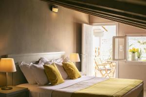 1 dormitorio con 1 cama grande con almohadas amarillas en Nimfi Hotel, Skiathos en Megali Ammos