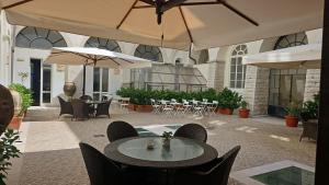patio ze stołami, krzesłami i parasolami w obiekcie San Paolo Al Convento w mieście Trani