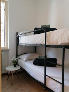 2 stapelbedden in een kamer met een tafel bij Casa Martin: appartamento piano terra in Peschiera del Garda
