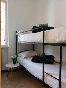 two bunk beds in a room with a table at Casa Martin apt piano terra By Case al Lago in Peschiera del Garda