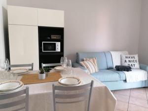 een woonkamer met een tafel en een blauwe bank bij Casa Martin: appartamento piano terra in Peschiera del Garda