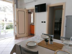 een tafel met borden en wijnglazen erop bij Casa Martin: appartamento piano terra in Peschiera del Garda