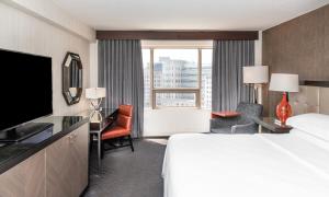 a hotel room with a bed and a large window at Sheraton Indianapolis City Centre Hotel in Indianapolis