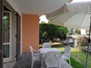 een tafel en stoelen en een parasol op een patio bij Casa Martin: appartamento piano terra in Peschiera del Garda