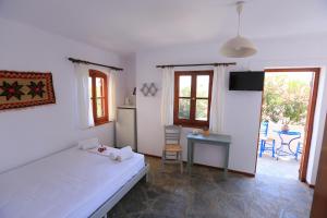 a bedroom with a bed and a table and a kitchen at ALKYONI in Skala