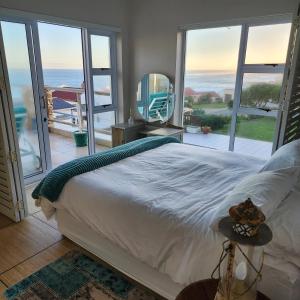 1 dormitorio con cama y vistas al océano en JONGENSFONTEIN, en Jongensfontein