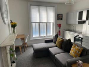 een woonkamer met een bank en een keuken bij BOURNECOAST: MODERN - TOWN CENTRE - BEACH - FM6140 in Bournemouth