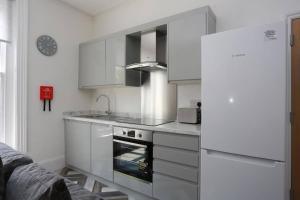 een keuken met witte kasten en een witte koelkast bij BOURNECOAST: MODERN - TOWN CENTRE - BEACH - FM6140 in Bournemouth