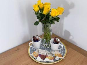 een tafel met een bord eten en een vaas met gele rozen bij BOURNECOAST: MODERN - TOWN CENTRE - BEACH - FM6140 in Bournemouth