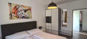 1 dormitorio con 1 cama y una pintura en la pared en Fremdenzimmer& Appartementhaus Blassnig, en Finkenstein