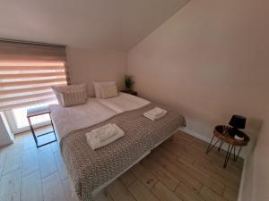 a bedroom with a bed with two towels on it at Ventė Stay apartment in Ventė