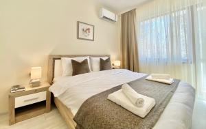 a bedroom with a large bed with two towels on it at Great 2BDR Apartment in the Centre for 6 Guests in Stara Zagora