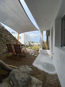 eine Terrasse mit 2 Stühlen und ein Gebäude in der Unterkunft THE VIEW OF MYKONOS in Mykonos Stadt