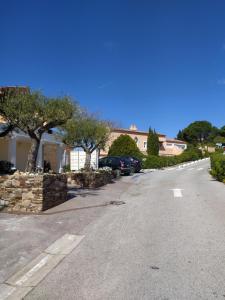una calle vacía con un coche aparcado en una entrada en Vacance location mer piscine var sud terrasse en Les Issambres