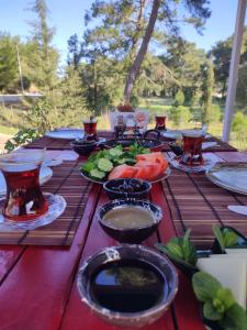 una larga mesa de madera con platos de comida. en Yolda Bungalow Cafe, en Kumluca