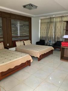 um quarto com 2 camas e uma sala de estar em Khách sạn CƯỜNG THÀNH em Thái Nguyên