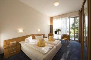 1 dormitorio con 1 cama grande con almohadas amarillas en Sonnenhotel Fürstenbauer, en Bodenmais