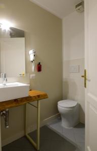 uma casa de banho com um lavatório branco e um WC. em Spagna Ave em Roma