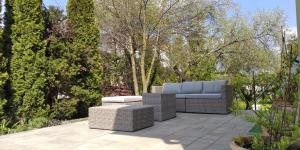 a patio with two wicker furniture and trees at Na Przypiecku in Piecki