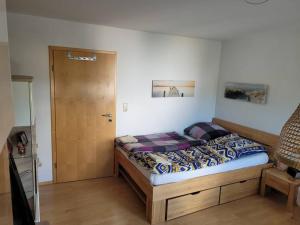1 dormitorio con 1 cama con marco de madera en 3-Room Apartment in Rowhouse - Oktoberfest, Trade Shows, Business, en Maisach