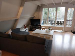 a living room with a couch and a table at Chalet 176 in Durbuy