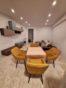 een woonkamer met een tafel en stoelen en een bank bij Emmaia Sunrise Luxury Appartment in Eforie Nord