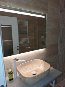 een badkamer met een grote houten wastafel en een spiegel bij Emmaia Sunrise Luxury Appartment in Eforie Nord