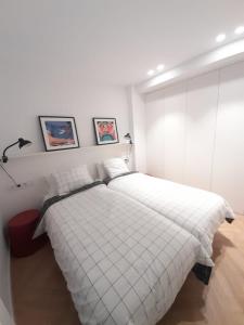 a bedroom with a large white bed in it at Alojamiento moderno y sofisticado con vistas a la ciudad in Bilbao