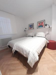 a bedroom with a bed with a white comforter at Alojamiento moderno y sofisticado con vistas a la ciudad in Bilbao