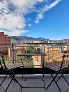 a table and chairs on a balcony with a view at Alojamiento moderno y sofisticado con vistas a la ciudad in Bilbao