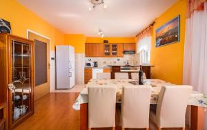 d'une cuisine avec une table, des chaises blanches et des murs jaunes. dans l'établissement Family villa with a pool near Pazin, à Pazin