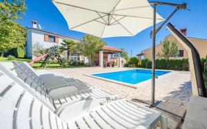 Cette villa dispose d'une piscine avec des chaises et un parasol. dans l'établissement Family villa with a pool near Pazin, à Pazin