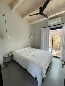 sypialnia z białym łóżkiem i wentylatorem sufitowym w obiekcie Casa Palma Pals 1 w mieście Pals