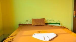 uma cama num quarto com uma parede verde em Maison d'Accueil - Fondation San Filippo Neri em Bujumbura